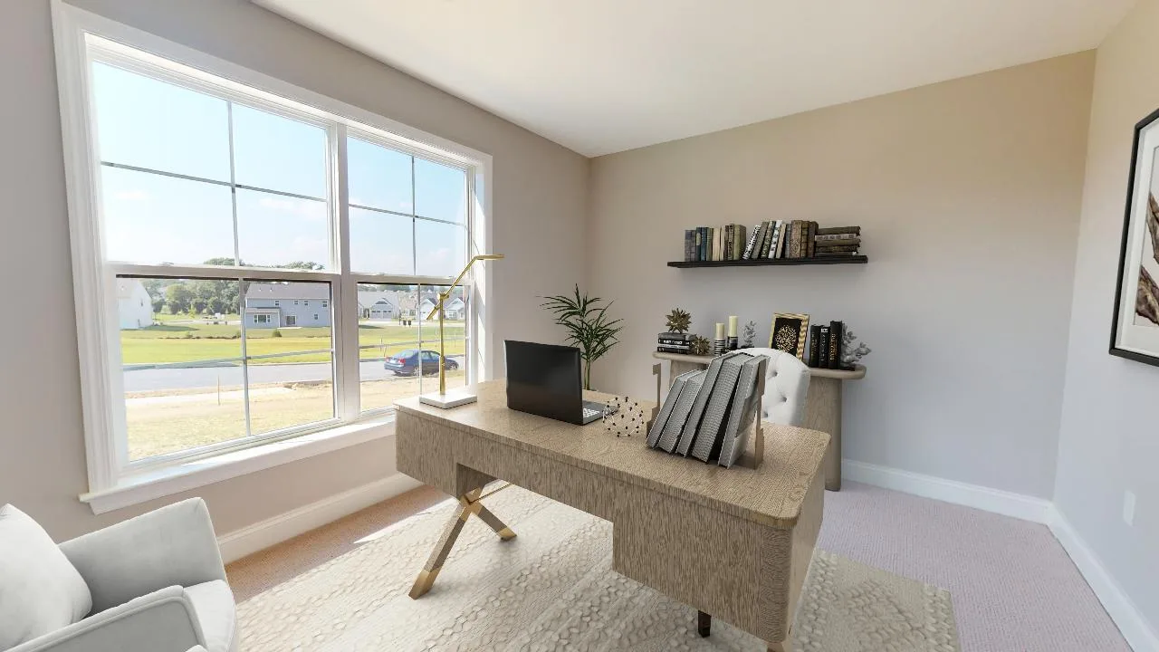 A bright home office with a large window, a wooden desk with a laptop and books, a chair, a shelf with books, and minimalist decor. Sunlight streams in, illuminating the neutral-colored room.