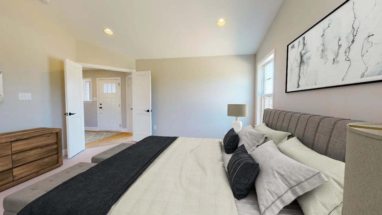 A modern bedroom with a neatly made bed, gray upholstered headboard, neutral bedding, a wooden dresser, a large abstract artwork on the wall, and open double doors leading to a bright hallway.